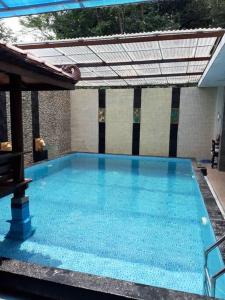 a large blue swimming pool with a roof at TITE homestay. Staycation feels @home in Salakan
