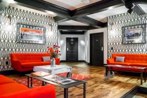 a living room with orange couches and a table at City Hall Grand Hotel in Williamsport