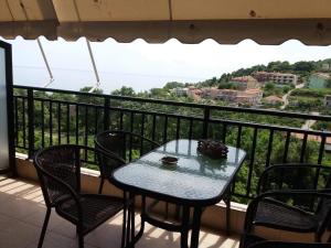 a table and chairs on a balcony with a view at Villa Gialos Rooms in Kokkino Nero