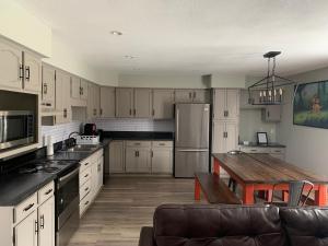 a kitchen with white cabinets and a wooden table at Hotel Marceline in Marceline