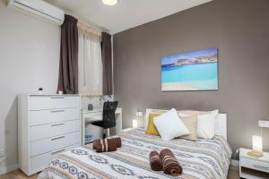 a bedroom with a bed with a dresser and the ocean at Luxury Msida Circle Suites in Msida
