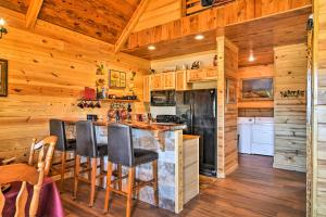 a kitchen with wooden walls and a counter with chairs at Hot Springs Cabin Rental 2 Mi to Lake Hamilton! in Hot Springs