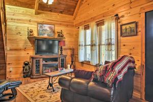 a living room with a leather couch and a television at Hot Springs Cabin Rental 2 Mi to Lake Hamilton! in Hot Springs