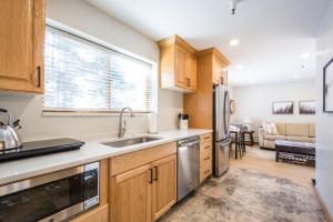 a kitchen with wooden cabinets and a stainless steel refrigerator at Powder Hound 1 Bedroom Brighton Chalet in Brighton
