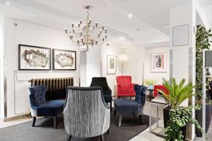 a living room with chairs and a table and a chandelier at Best Western Plus Hotell Nordic Lund in Lund