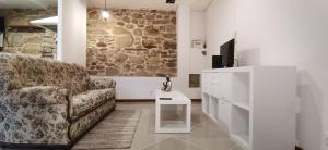 a living room with a couch and a tv at Casinha da Capela 1935 in Caminha