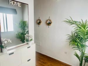 baño con espejo y plantas en la pared en Dakota’s house, en La Laguna