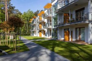 an apartment building with a lawn in front of it at Apartament Holiday B 210 in Pobierowo