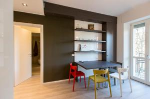 uma sala de jantar com uma parede preta e cadeiras coloridas em Apartment Melozzo em Milão