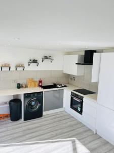a white kitchen with a washer and a dishwasher at Lovely Modern 2 Bed Flat /w parking, close to town in Manchester