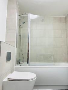 a white bathroom with a shower and a toilet at Lovely Modern 2 Bed Flat /w parking, close to town in Manchester