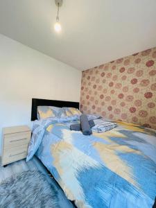 a bedroom with a bed with a blue comforter at Lovely Modern 2 Bed Flat /w parking, close to town in Manchester