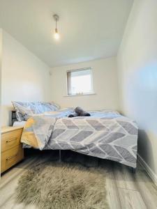 a bedroom with a bed and a window at Lovely Modern 2 Bed Flat /w parking, close to town in Manchester