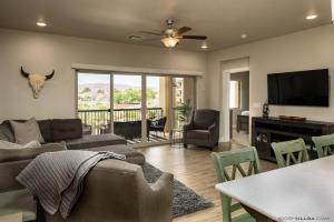 a living room with a couch and a table with chairs at S301-Hilltop Hideaway-Third Floor 3-bedroom Pool View in St. George
