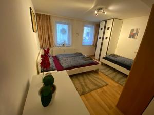 um pequeno quarto com 2 camas e um vaso sobre uma mesa em Ferienhaus Greiz em Greiz