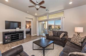 a living room with couches and a television and a bed at S404-The Penthouse-Fourth Floor 3-bedroom Pool View in St. George