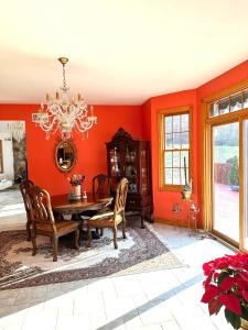 comedor con paredes rojas, mesa y sillas en Villa Verde B&B, bsm, Greenwood Lake, NY en Monroe