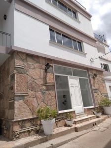 ヴィラ・カルロス・パスにあるBalcones del Cerro Departamento con cocheraの石壁と窓のある家 +3枚の写真