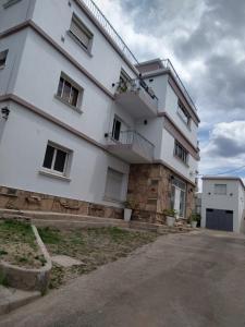 ヴィラ・カルロス・パスにあるBalcones del Cerro Departamento con cocheraのたくさんの窓がある大きな白い建物