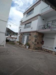 ヴィラ・カルロス・パスにあるBalcones del Cerro Departamento con cocheraのバルコニー付きの白いアパートメントです。