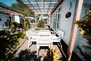 a row of white chairs on the porch of a house at Camping Molo Surf SPOT in Jastarnia