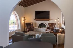 a living room with chairs and a flat screen tv at Spacious Arcadia Lite house w pool mtn views in Phoenix