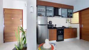 a kitchen with a stainless steel refrigerator and a stove at Superbly Modern and Airy Two Bedroom Seaside Apartment with Balcony in Bijilo