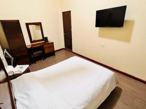 a hotel room with a bed and a television at Hotel Nueva Antequera in Oaxaca City