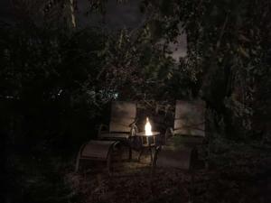 - deux chaises et une table avec une bougie la nuit dans l'établissement Las Liebres, à Molinari