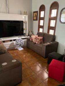 sala de estar con sofá y TV de pantalla plana en Casa, en São Gabriel