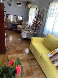 sala de estar con sofá amarillo y árbol de Navidad en Casa, en São Gabriel