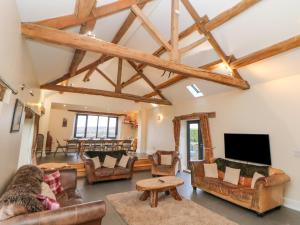 uma sala de estar com mobiliário de couro e vigas de madeira em The Old Robin Hood em Holmesfield