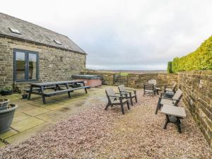 a patio with picnic tables and benches next to a brick building at The Old Robin Hood in Holmesfield