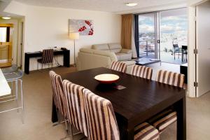 a living room with a wooden table and chairs at Toowoomba Central Plaza Apartment Hotel Official in Toowoomba