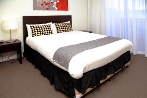 a large bed in a hotel room with a large white bed sidx sidx at Toowoomba Central Plaza Apartment Hotel Official in Toowoomba