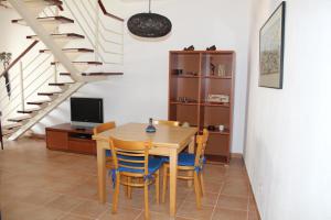 a dining room with a table and chairs and a staircase at FM Central Vila Apartment in Carvoeiro