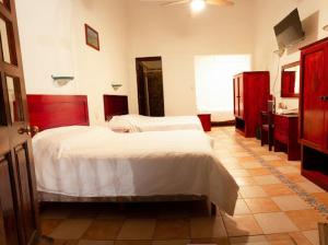 a bedroom with two beds and a bathroom with a sink at Hotel Nueva Antequera in Oaxaca City