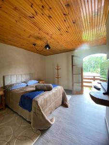 1 dormitorio con cama y techo de madera en CANTINHO DO SOSSEGO, en Campos do Jordão