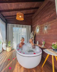 Dos personas en una bañera en una habitación en Cabana Encantos da Lagoa, en Imbituba