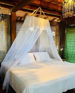 1 dormitorio con 1 cama con mosquitera en Bungalows Tukitlan en Zihuatanejo