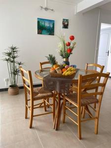 a dining room table with a bowl of fruit on it at Kay Sandra à 2 mn du CHU in Saint-Joseph