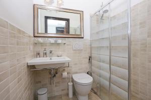 a bathroom with a toilet and a sink and a mirror at Houspitality Caesar Bed & Breakfast in Rome