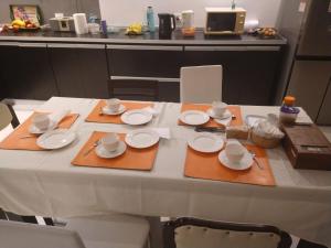 una mesa con platos y utensilios. en Las Loicas B&B en Esquel