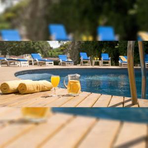 格塞尔镇特拉萨斯俱乐部酒店的一张桌子,旁边是游泳池,旁边是一杯橙汁