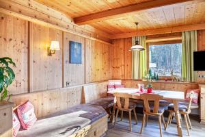 a dining room with a table and chairs at Ferienwohnung Platzhirsch Panorama View Balkon, Gartensauna, Garten, Grillplatz in Stumm