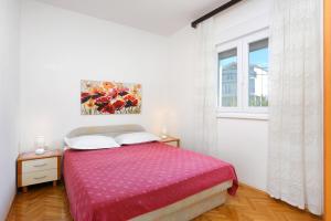 een slaapkamer met een bed en een raam bij Apartments by the sea Seget Vranjica, Trogir - 18487 in Donji Seget