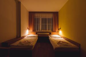 a room with three beds in front of a window at Hotel Annahof in Domašov