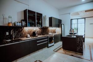 a large kitchen with black cabinets and appliances at Pura Vida Concordia in Concordia