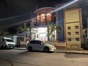 a white car parked in front of a building at The Colosseum in Basse Terre Town