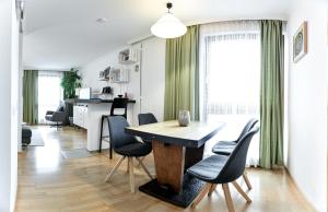 - une salle à manger et une cuisine avec une table et des chaises dans l'établissement Ferienwohnung in der Sonnenstadt Lienz, à Lienz